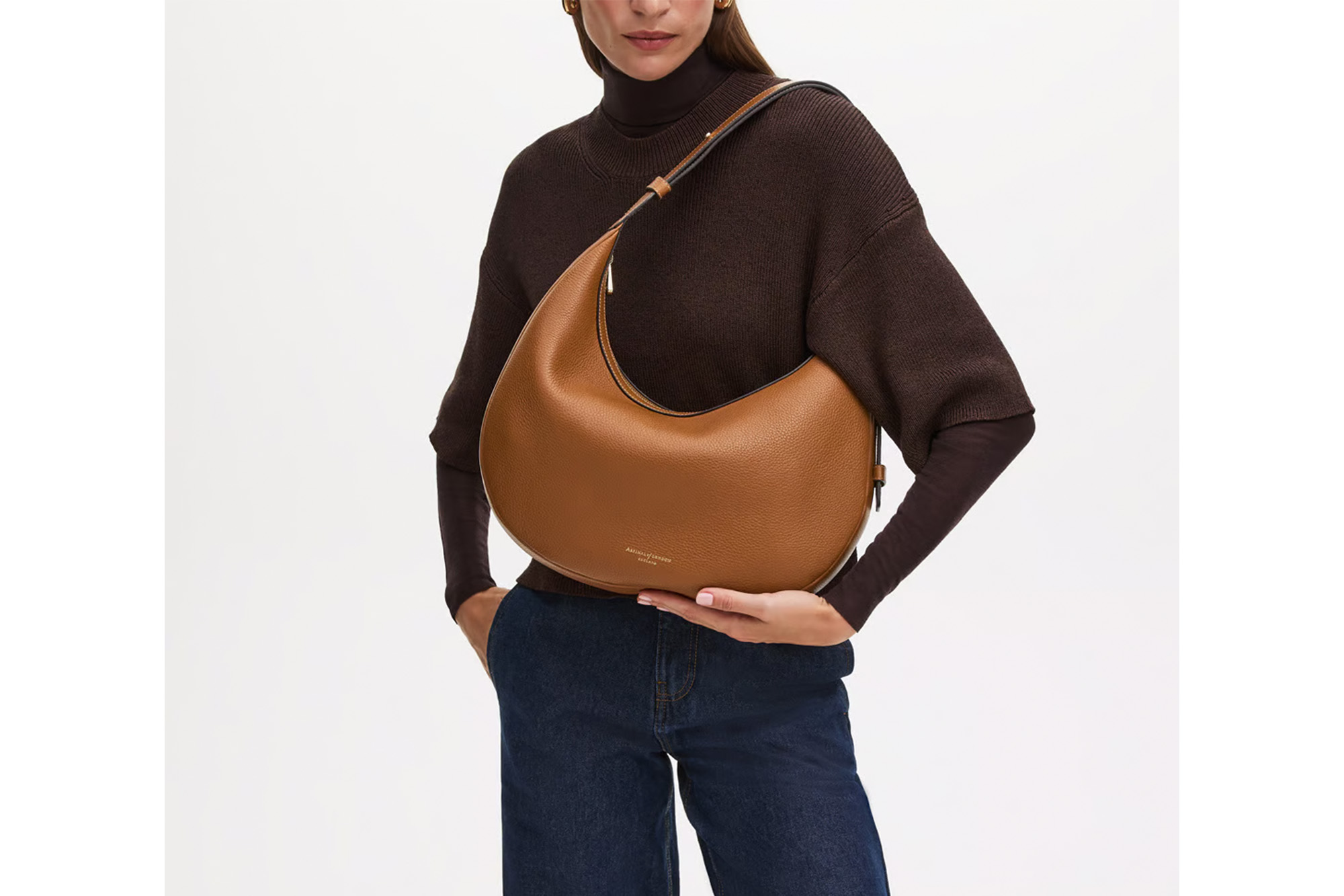 A model carrying a crescent-shaped bag