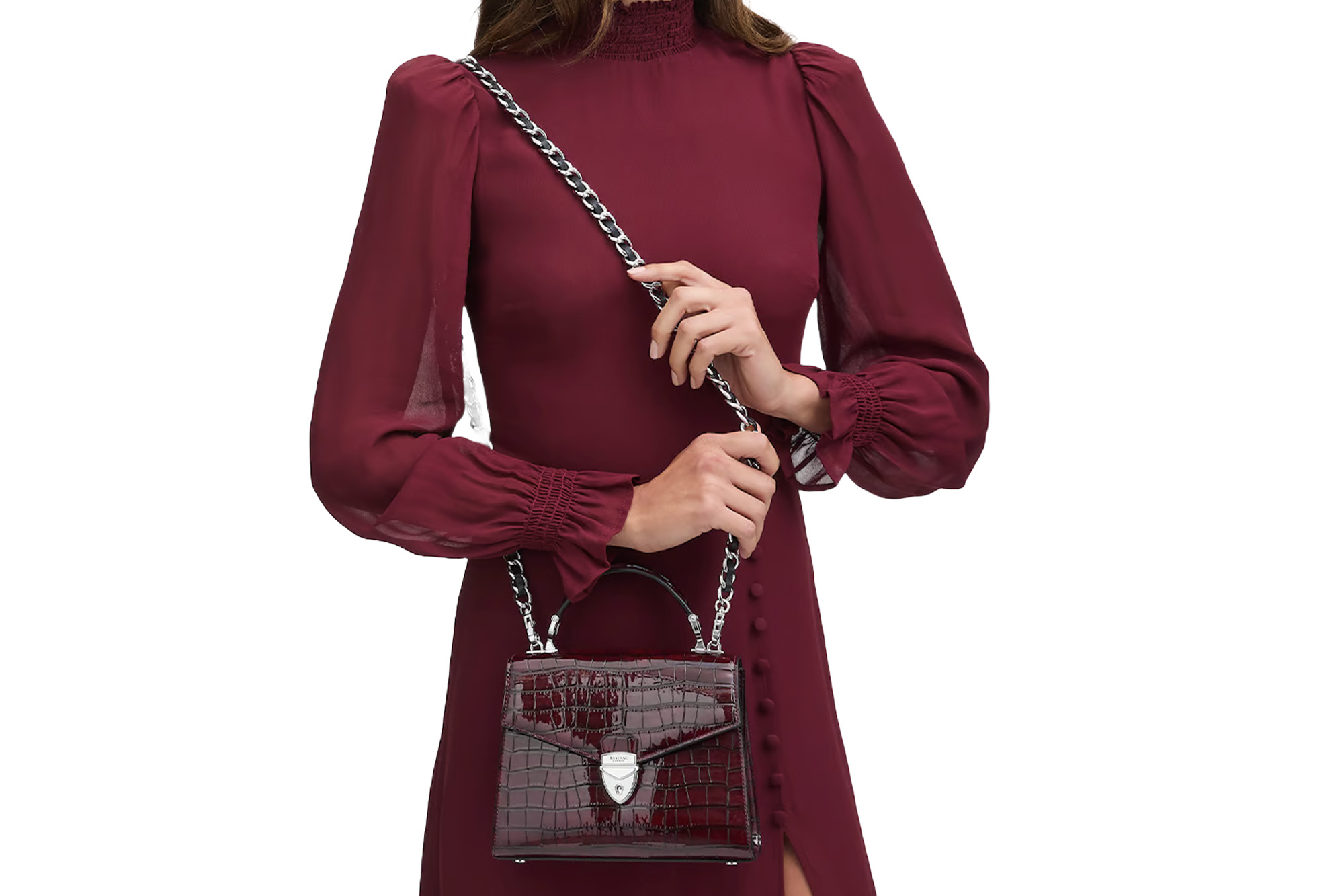 A model carrying a burgundy bag