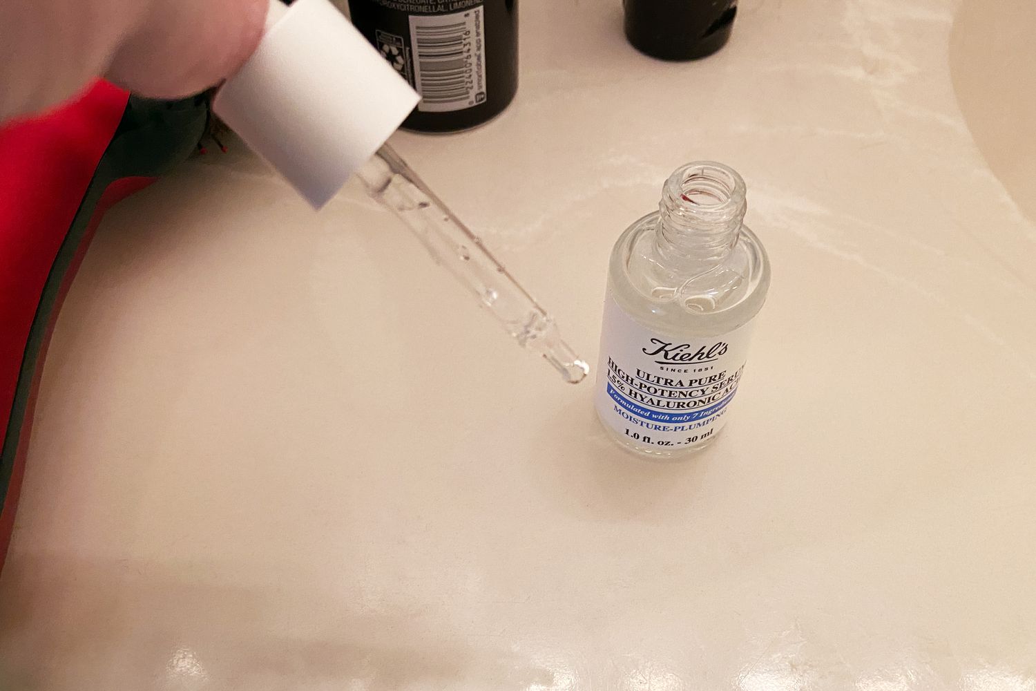 Hand holding the Kiehl's Ultra Pure 1.5% Hyaluronic Acid Serum dropper