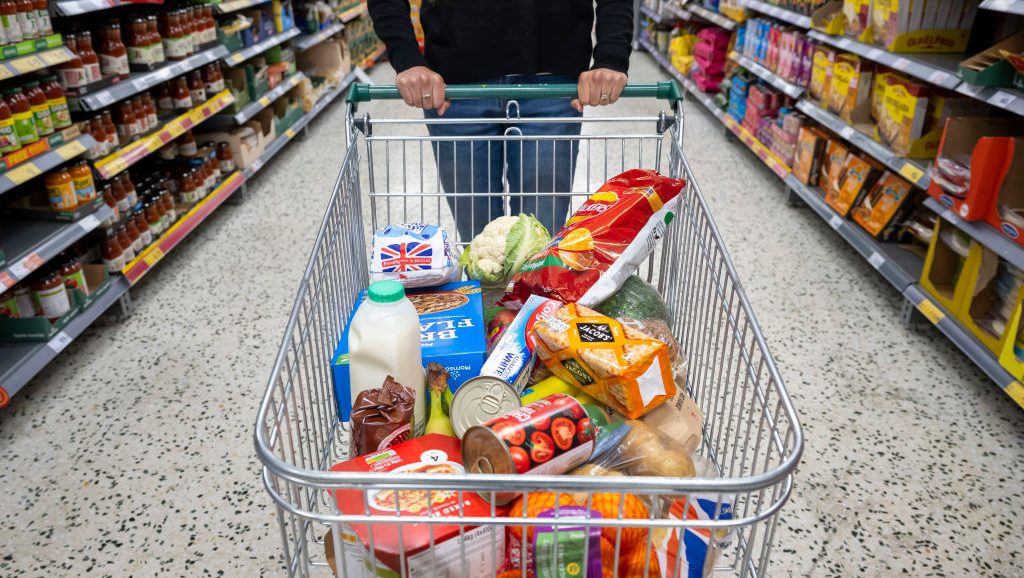 CARDIFF, WALES - MAY 22: A woman with a shopping trolley full of groceries in a supermarket aisle on May 22, 2022 in Cardiff, Wales. Last week, the UK Office for National Statistics reported an 6% average increase of food and drink prices year on year, but some staples, such as milk and pasta, had risen by more than 10%. (Photo by Matthew Horwood/Getty Images)