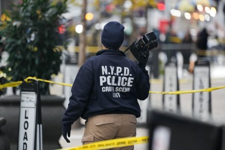 A Crime Scene Unit officer photographs the scene where CEO of UnitedHealthcare Brian Thompson, 50, was shot as he entered the New York Hilton early on December 4, 2024 in New York. Brian Thompson, the chief executive of one of the United States's largest health insurance companies, UnitedHealthcare, was shot and killed outside a New York Hilton hotel in an apparently targeted hit Wednesday, US media reported. (Photo by Bryan R. SMITH / AFP) (Photo by BRYAN R. SMITH/AFP via Getty Images)