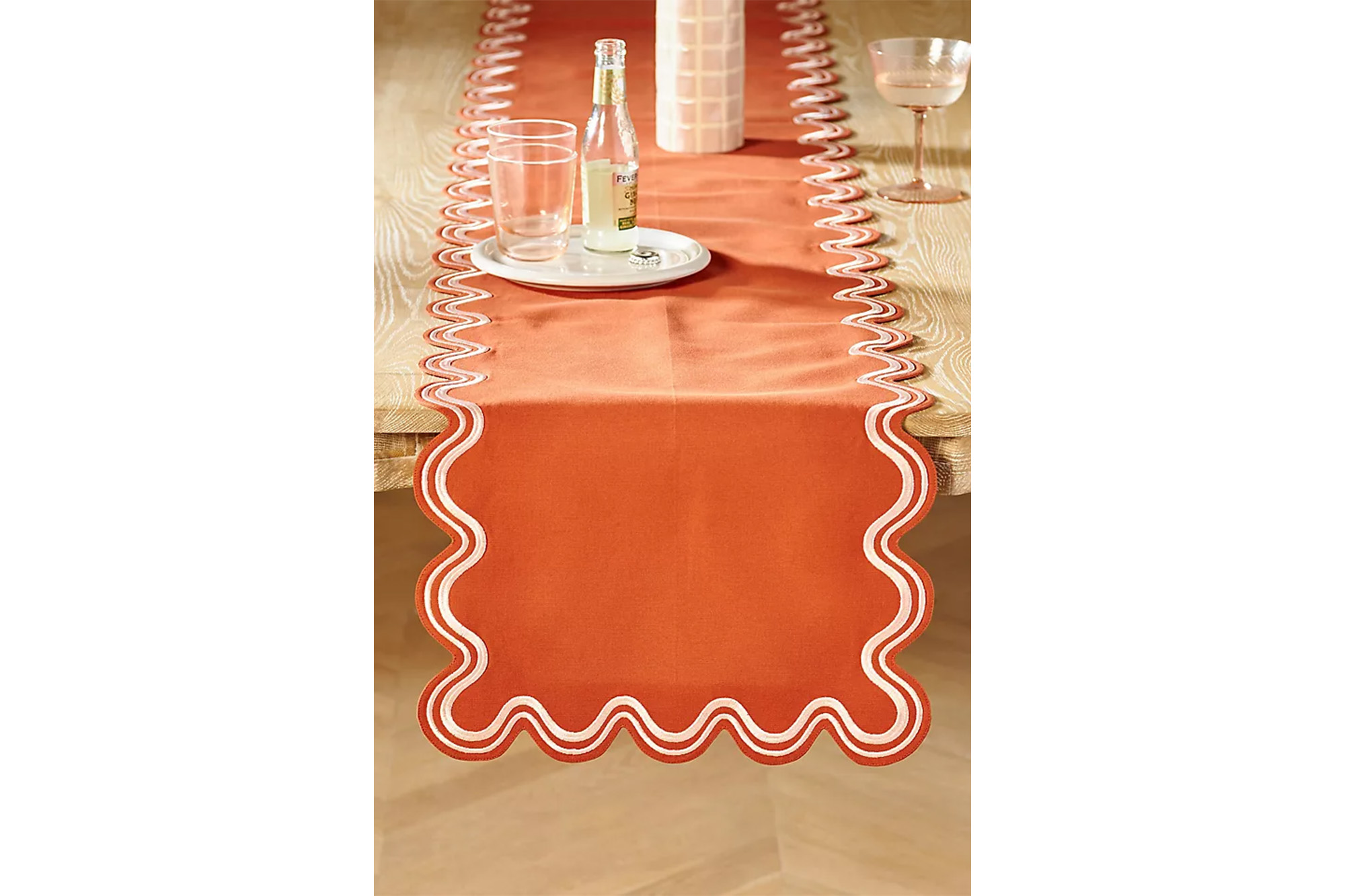 An orange table runner with scalloped edges