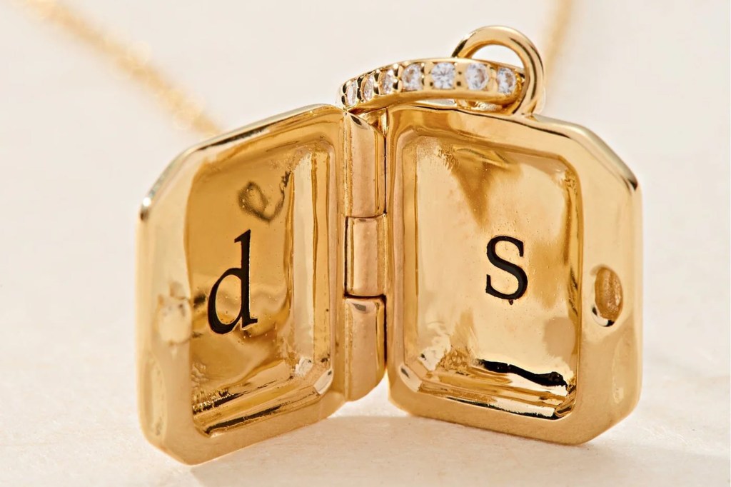 Gold locket engraved with letters "d" and "s" on a gold chain.
