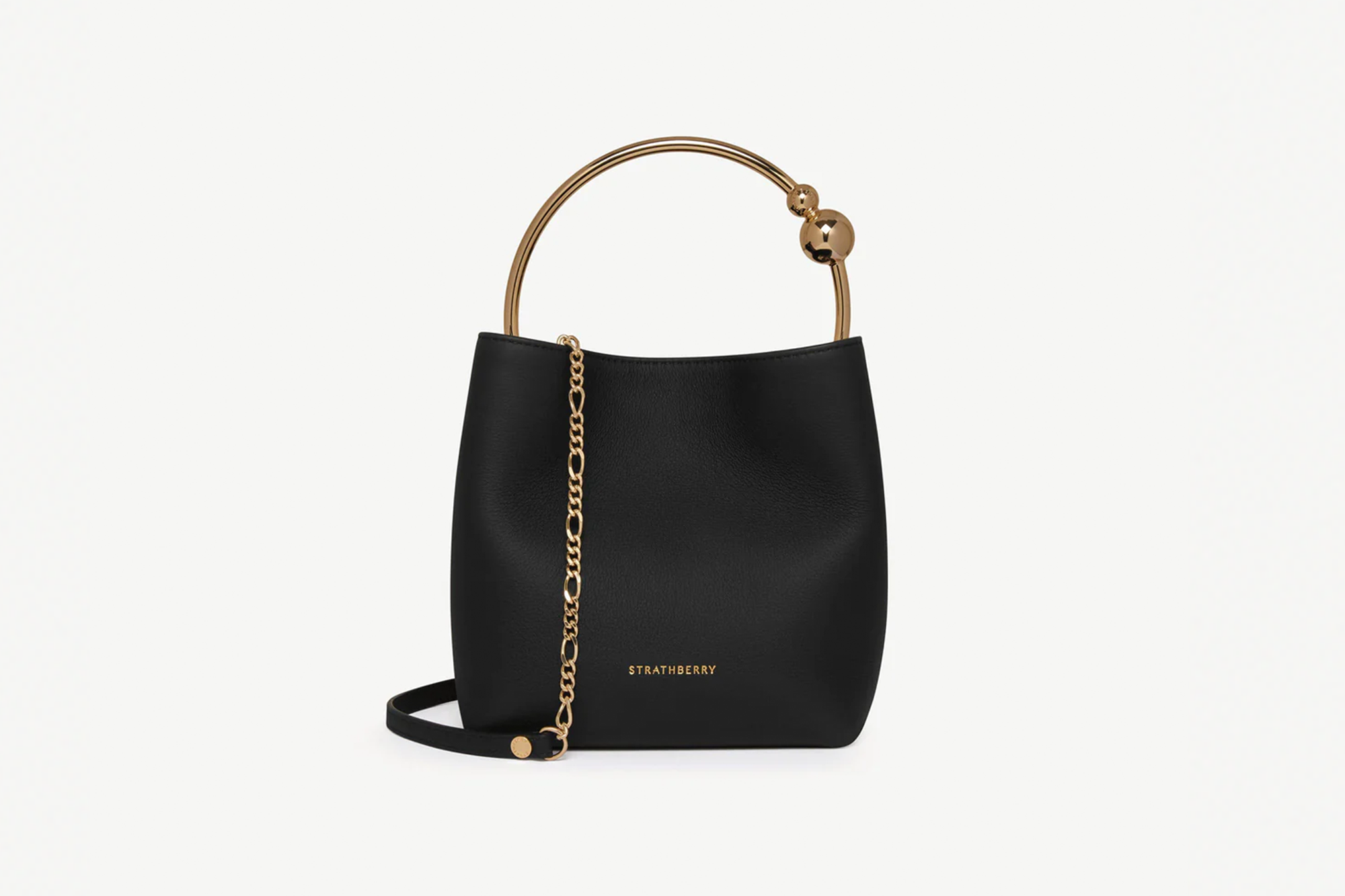 A black Strathberry tote bag with a circular gold handle and a gold chain strap.
