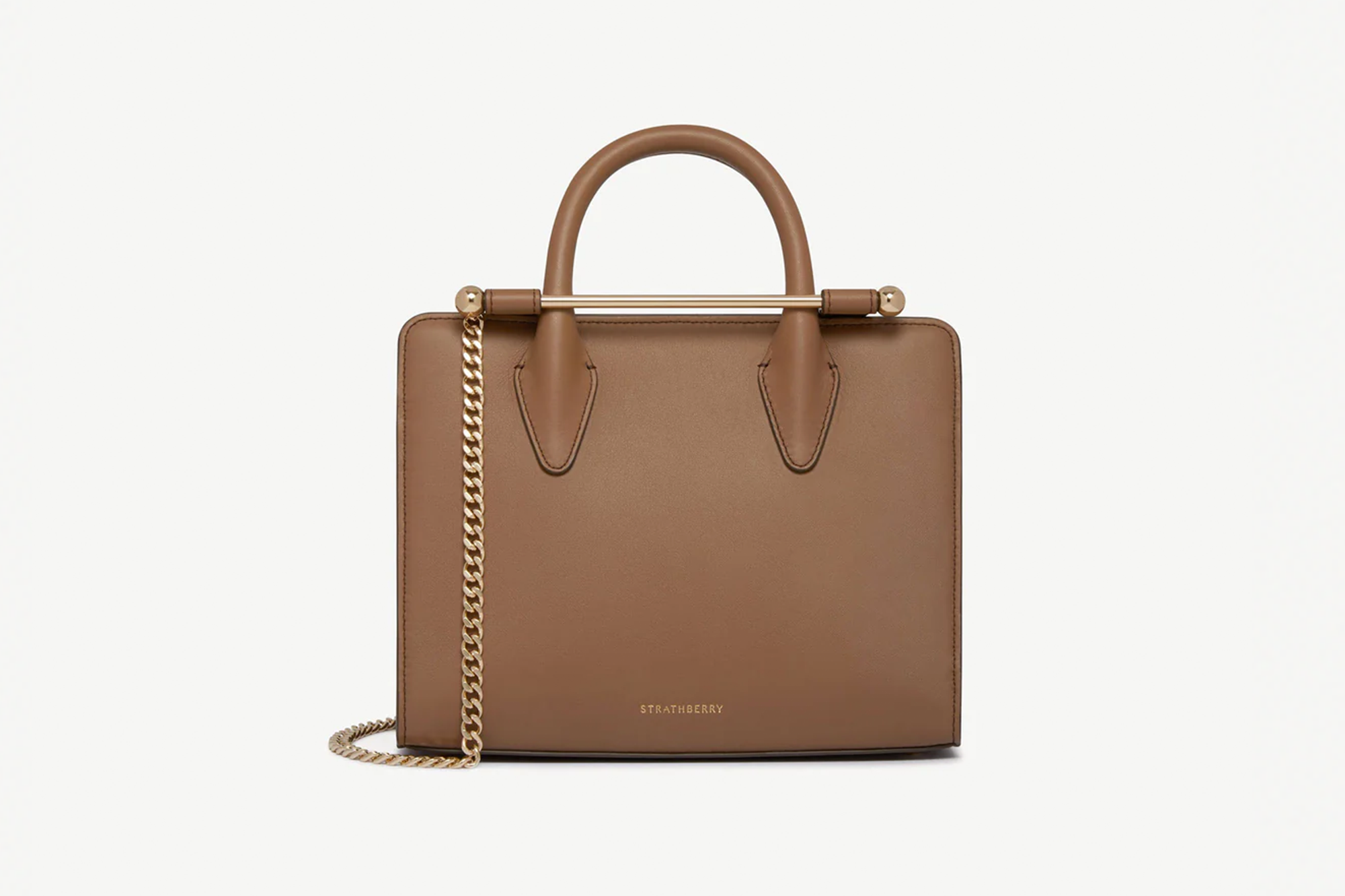 Strathberry tan leather handbag with a top handle and a gold chain.