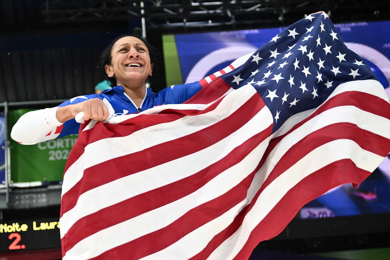 USA's Elana Meyers Taylor waves an US flag after winning gold in the bobsleigh women's monobob heat 4 at Cortina Sliding Centre during the Milano Cortina 2026 Winter Olympic Games in Cortina d'Ampezzo on February 16, 2026. Marco BERTORELLO / AFP via Getty