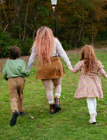 A woman with two children holding hands walking outdoors on a grassy area Lauren Clark (center) with her two kids Courtesy of Lauren Clark