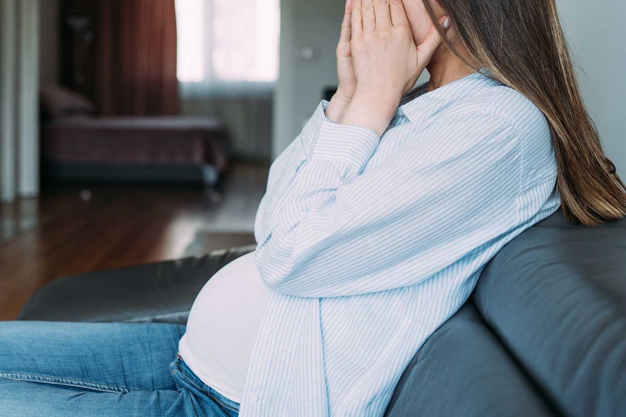 Stock photo of distressed pregnant woman sitting on couch A pregnant woman (stock image)Credit: Getty Stock Images