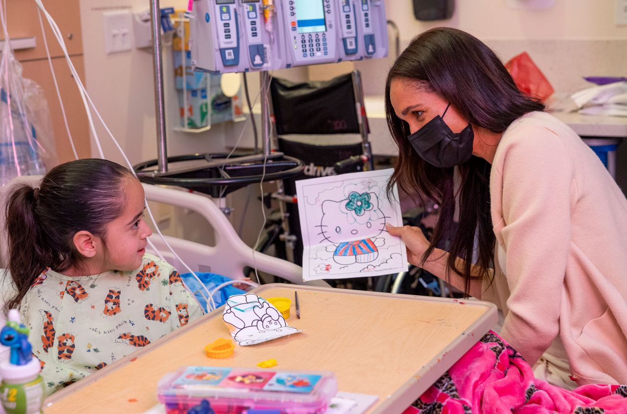 The Duchess of Sussex colors a 'Hello Kitty' picture with a patientCredit: CHLA
