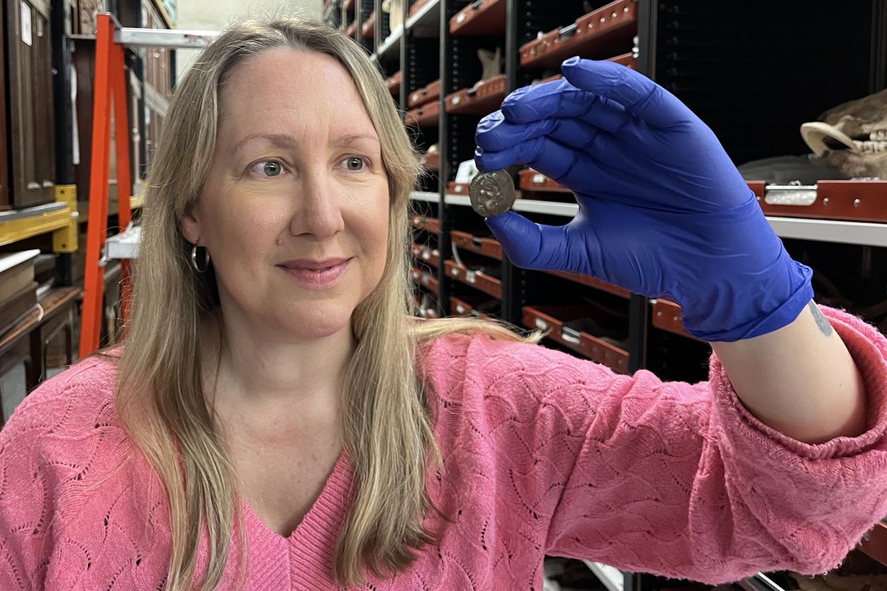 Kat Baxter, Leeds Museums and Galleries' curator of archaeology and numismatics, holding the ancient coinCredit: Leeds City Council
