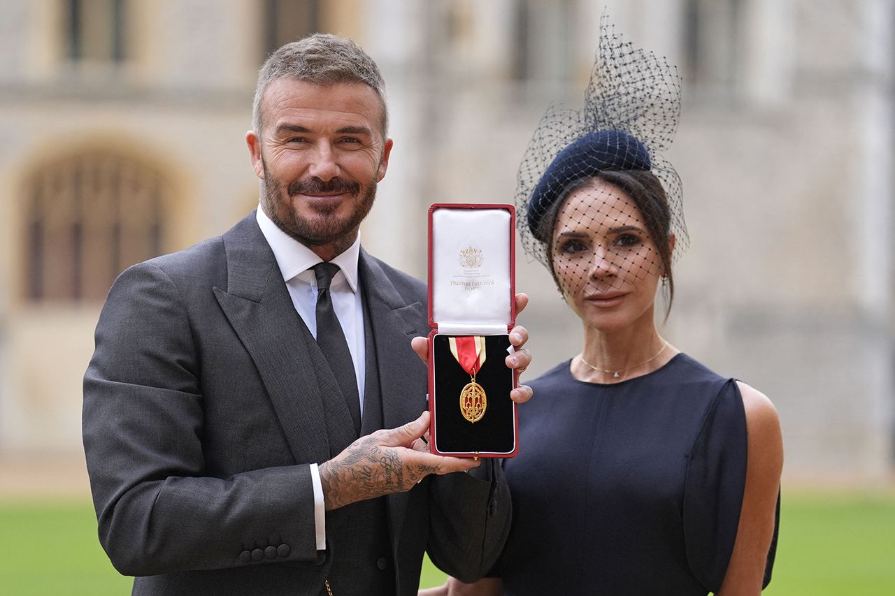 Former England footballer David Beckham (L) poses next to his wife singer and fashion designer Victoria Beckham (R) with his medal after being appointed as a Knight Bachelor (Knighthood) for services to sport and charity David and Victoria Beckham at the former professional soccer player's investiture ceremony on Nov. 4, 2025Credit: ANDREW MATTHEWS/POOL/AFP via Getty