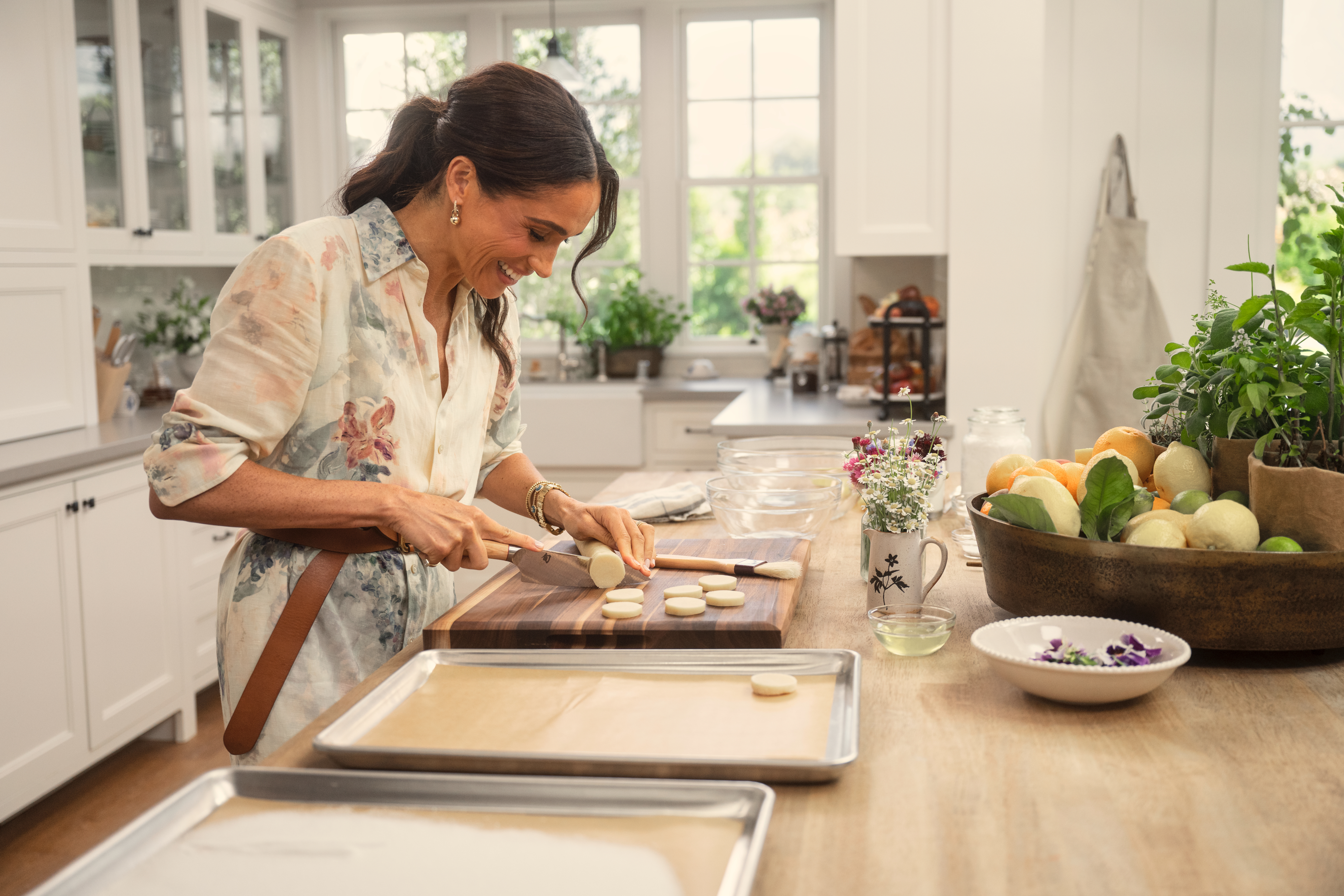 Meghan Markle cutting circular pieces of dough from a rolled log.