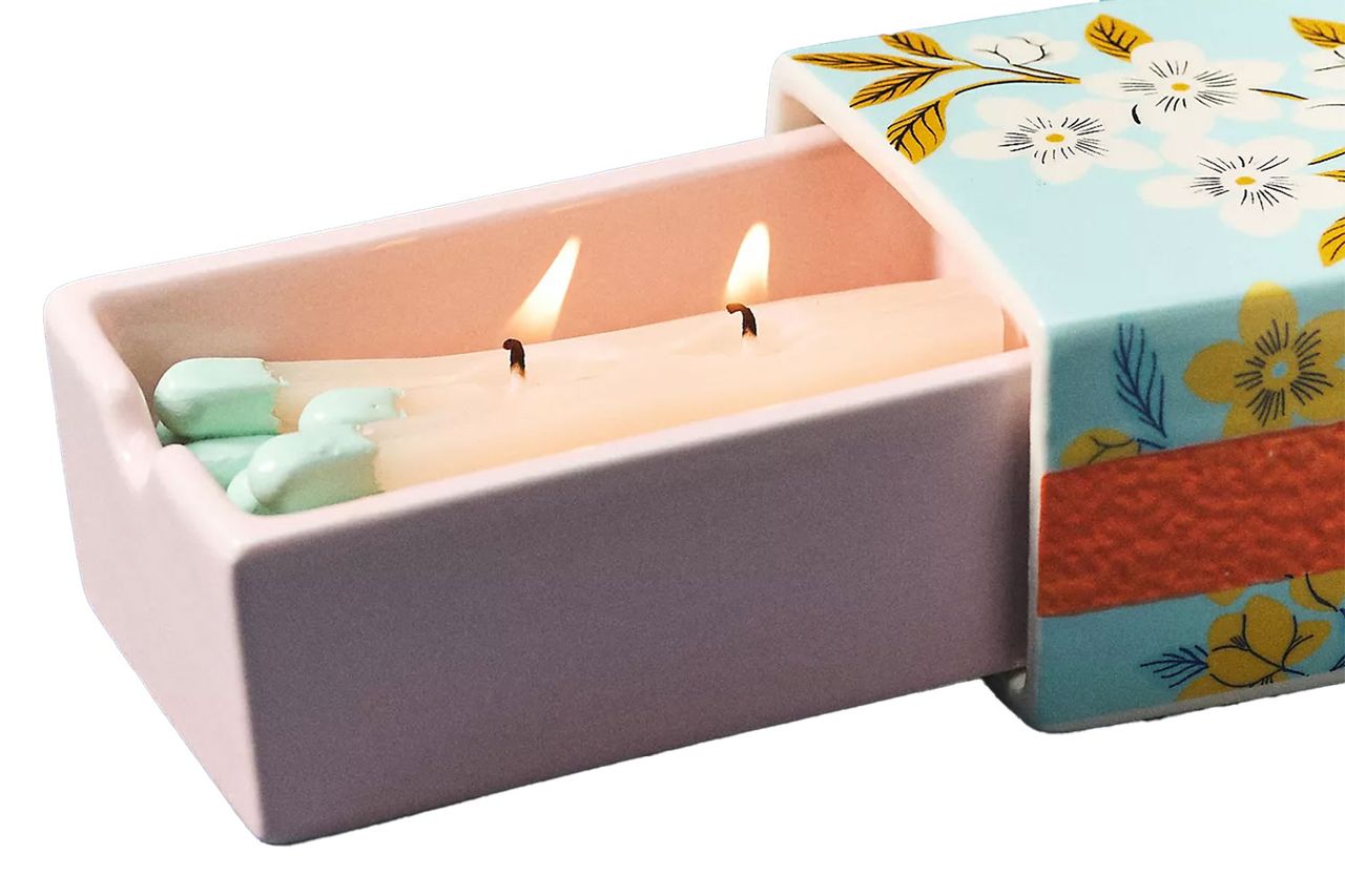 A ceramic box with a floral lid containing a lit candle Credit: Anthropologie