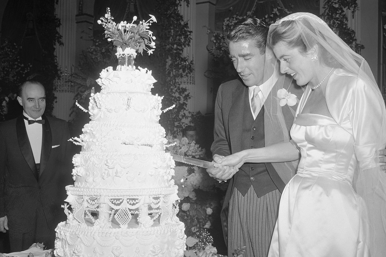Bride and Groom Cut Cake. New York: Patricia Kennedy, daughter of multi-millionaire former U.S. Ambassador to the court of St. James, Joseph P. Kennedy and husband Peter Lawford, Hollywood actor, cut their wedding cake at the reception held in the Grand Ballroom of the Hotel Plaza in New York City. The nuptials were held in the church of St. Thomas More, with the Rev. John J. Cavanaugh, former president of Notre Dame University, officiating. The couple will honeymoon in Hawaii. Patricia Kennedy, daughter of multi-millionaire former U.S. Ambassador to the court of St. James, Joseph P. Kennedy and husband Peter Lawford, Hollywood actor, cut their wedding cakeCredit: Bettmann/Getty