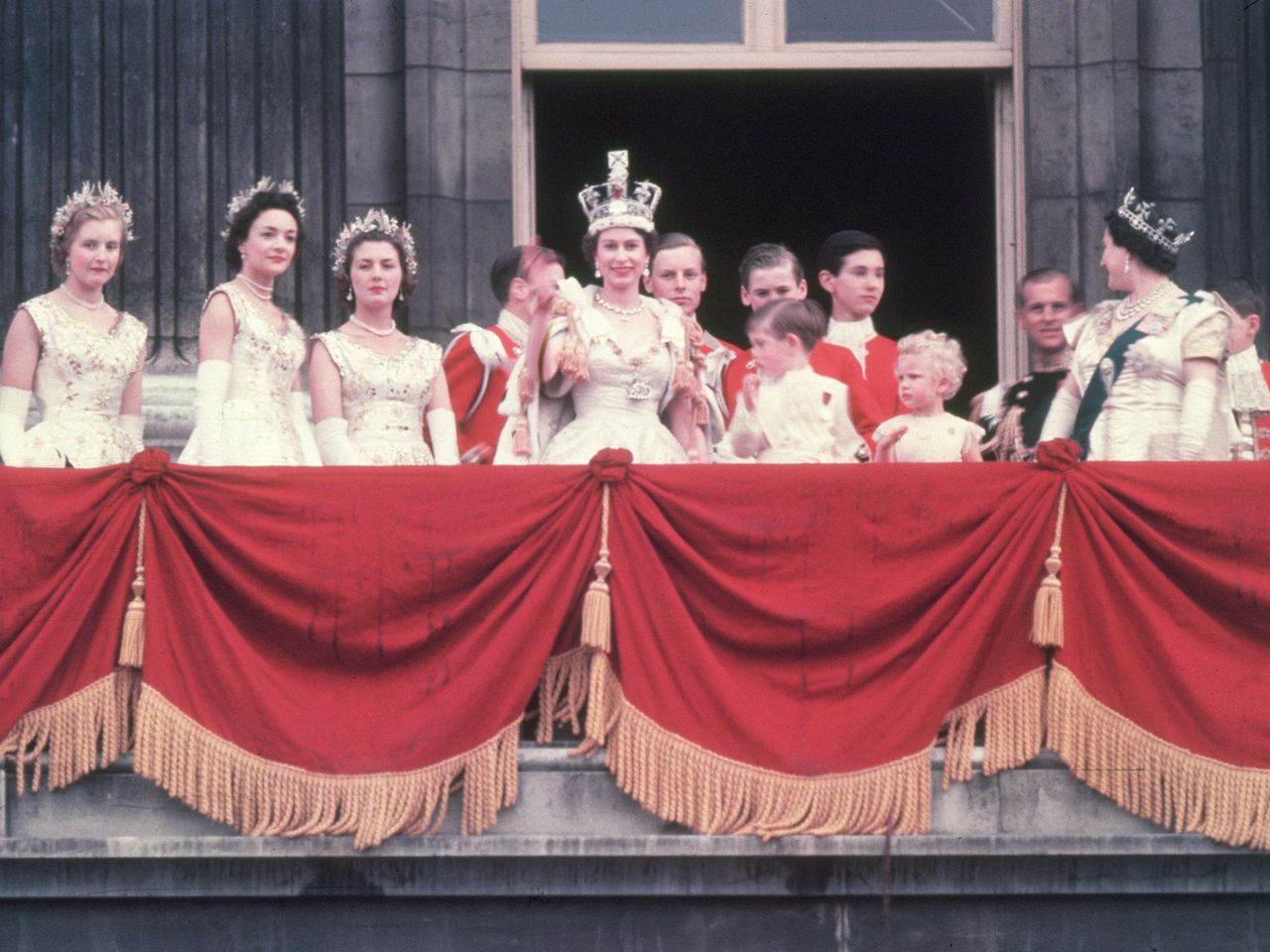 The newly crowned Queen Elizabeth waves to the crowd from the balcony at Buckingham PalaceCredit: Hulton Archive/Getty
