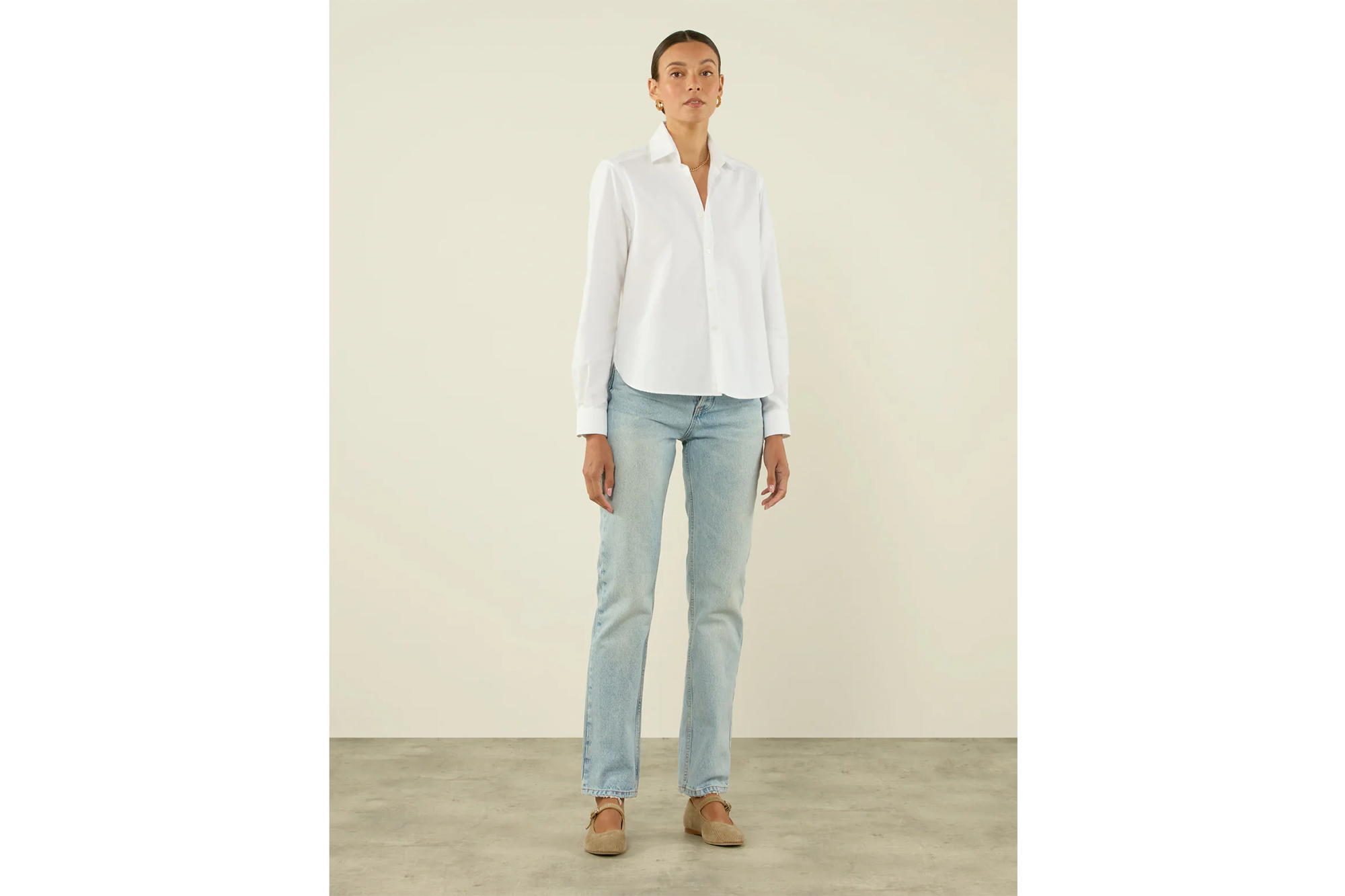 Woman wearing an Oxford shirt and jeans.