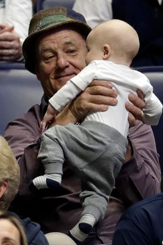 Bill Murray holds a baby during the NCAA college basketball tournament onMarch 16, 2018in Nashville, Tenn. Bill Murray holding one of his grandchildren at a Xavier basketball game in 2018Credit: Mark Humphrey/AP Photo