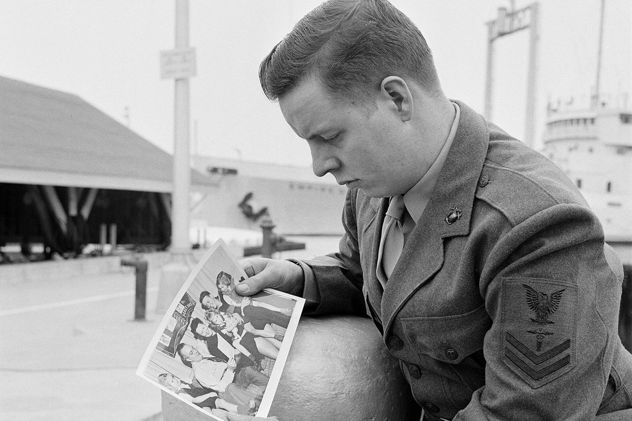 Donald Martin pictured in 1959 looking at a 1952 Christmas photo of his missing familyCredit: AP Photo