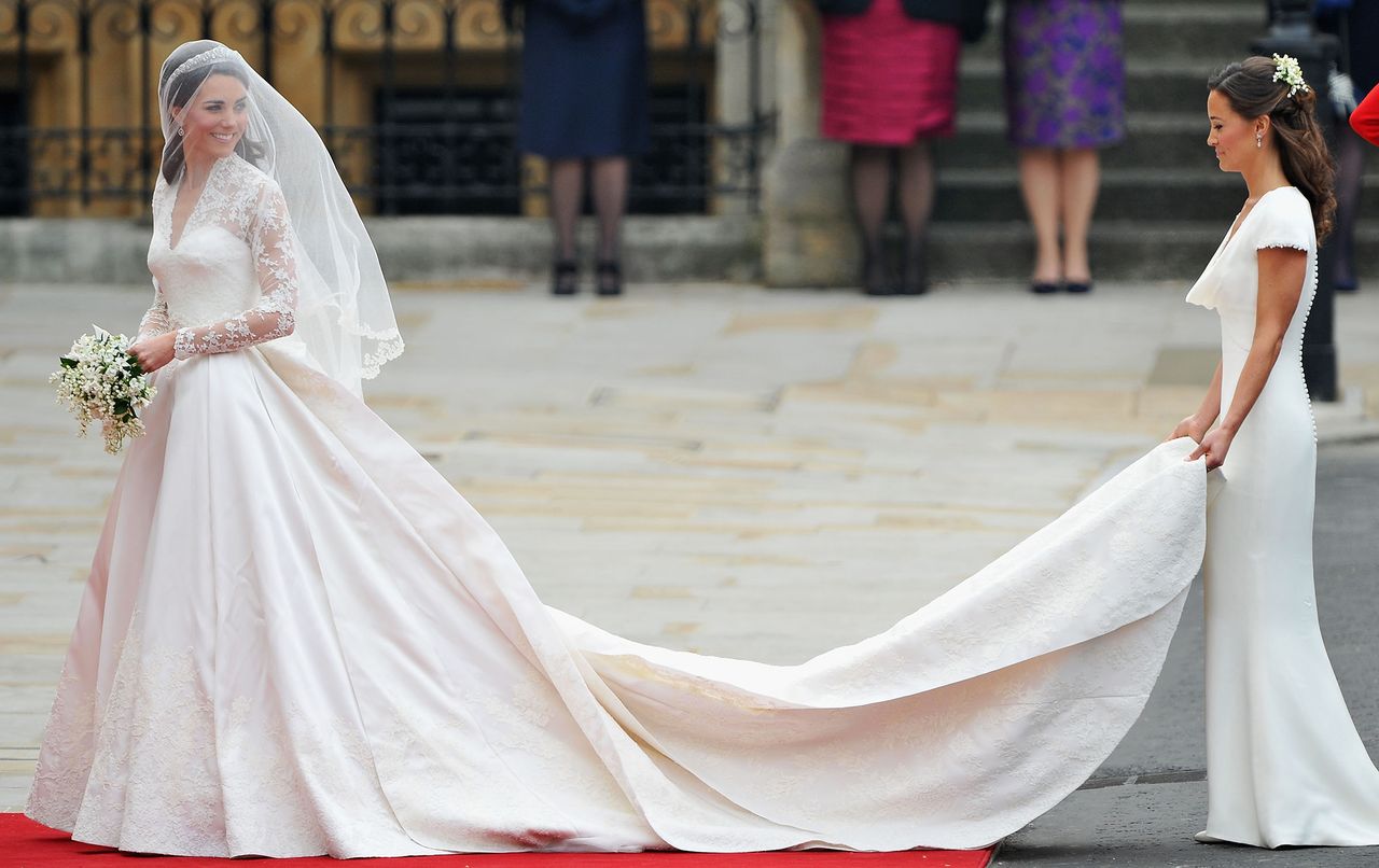 Catherine Middleton waves to the crowds as her sister and Maid of Honour Pippa Middleton holds her dress before walking in to the Abbey to attend the Royal Wedding of Prince William to Catherine Middleton at Westminster Abbey on April 29, 2011 in London, England.Credit: Pascal Le Segretain/Getty
