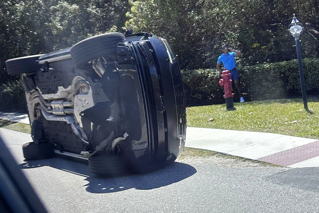 Tiger Woods stands by his overturned vehicle in Jupiter Island, Fla.Credit: AP Photo/Jason Oteri
