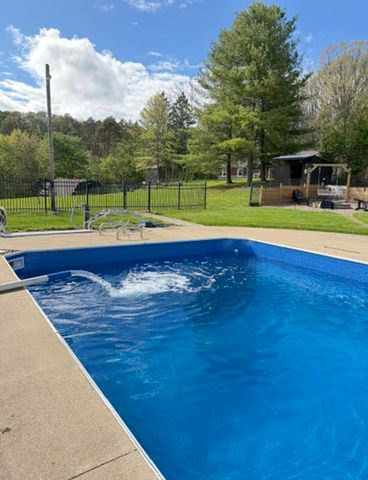 A swimming pool in a backyard with a fence trees and a view of a lawn and houses in the background The finish poolCredit: Alyssa Lynn Hartrick