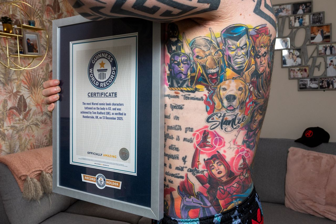 Tom Radford showing off his Guinness World Record plaque and tattoos.Credit: Charley Atkins/SWNS