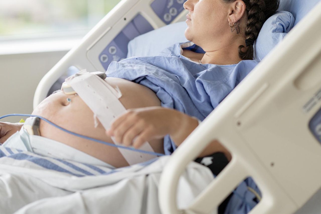 A pregnant woman lies in a hospital bed during labor, connected to monitoring devices. Stock image of a pregnant woman being monitored in a hospitalCredit: Getty