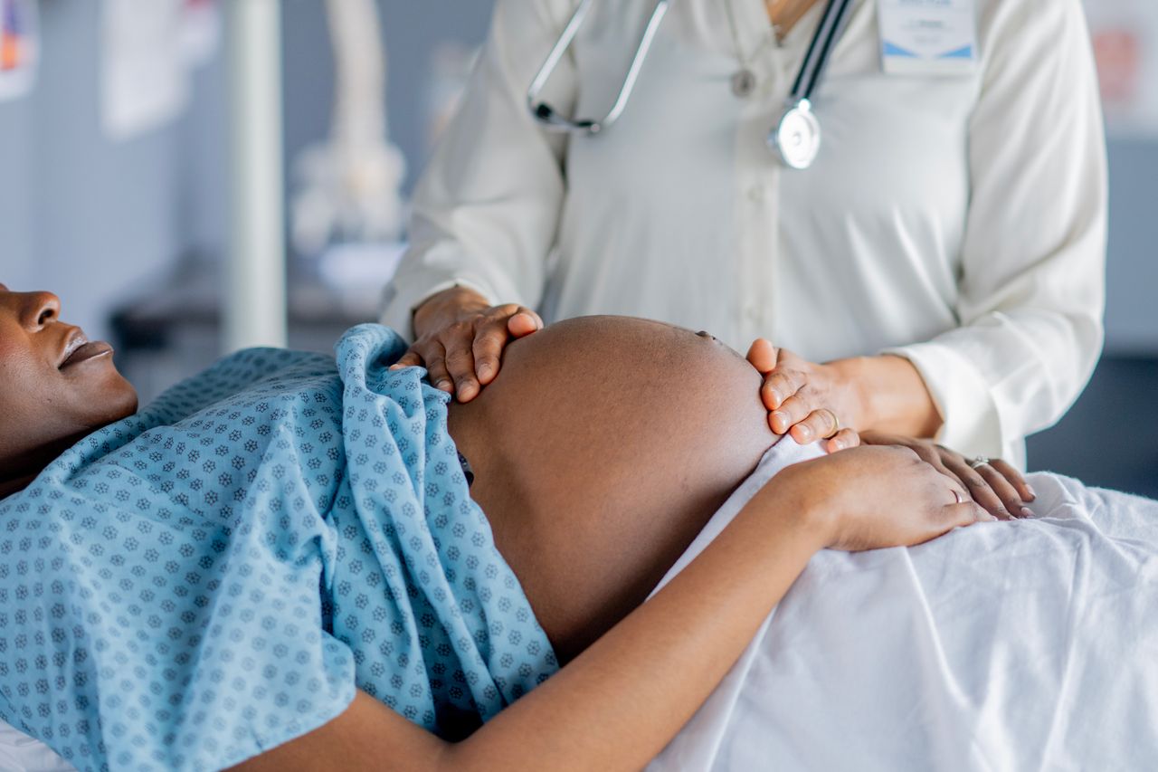 A young pregnant woman lays Stock image of a pregnant womanCredit: Getty