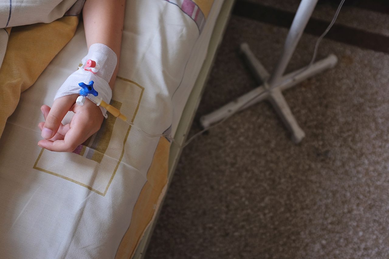 Child's hand in hospital bed, with IV drip attached Child in a hospital bed with an IV dripCredit: Getty