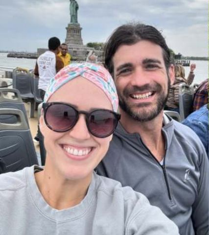 Two individuals outdoors with the Statue of Liberty in the background smiling at the camera Jen and Brian Hamilton.Credit: jenhamilton_/X