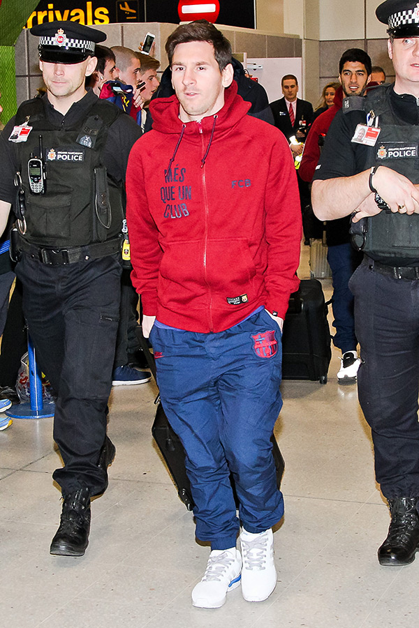 Lionel Messi in between two police officers