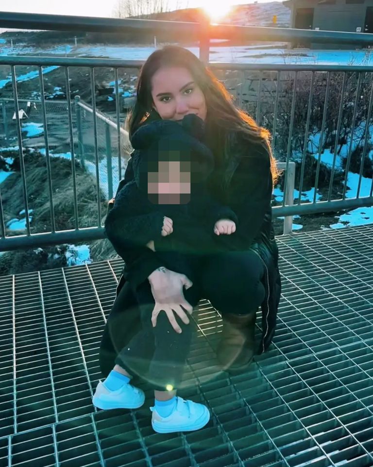 A woman crouching on a metal walkway outdoors holding a baby bundled up in winter clothing Carolina Moreno and her son.Credit: Jorge Carrera