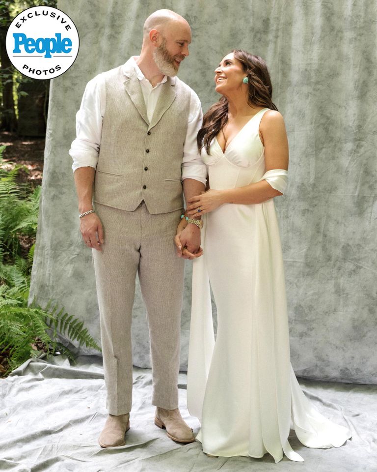 Jessica Vosk, in an Amsale gown, hold hands with David Godar while posing in the woods at June Farms on the day their welcome dinner for their wedding weekendCredit: Laurel Hinton