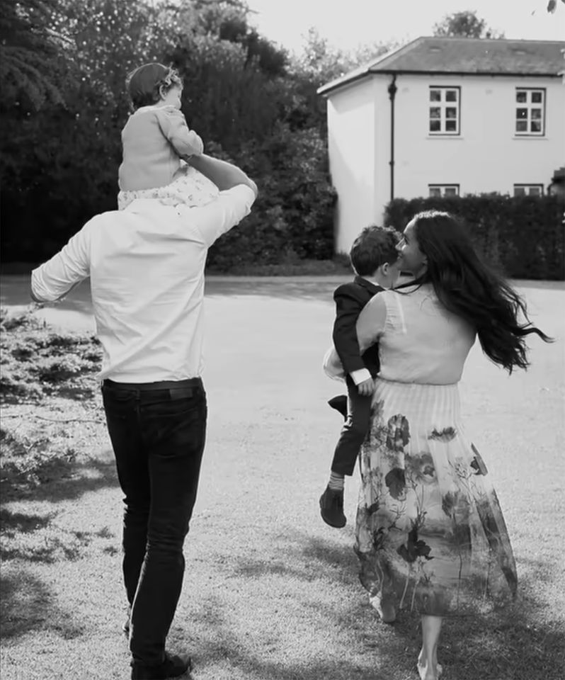 Black-and-White Photo of Prince Harry with Lilibet on His Shoulders and Meghan Markle Looking Up At Her While Carrying Archie Prince Harry, Princess Lilibet, Prince Archie and Meghan MarkleCredit: Netflix/YouTube