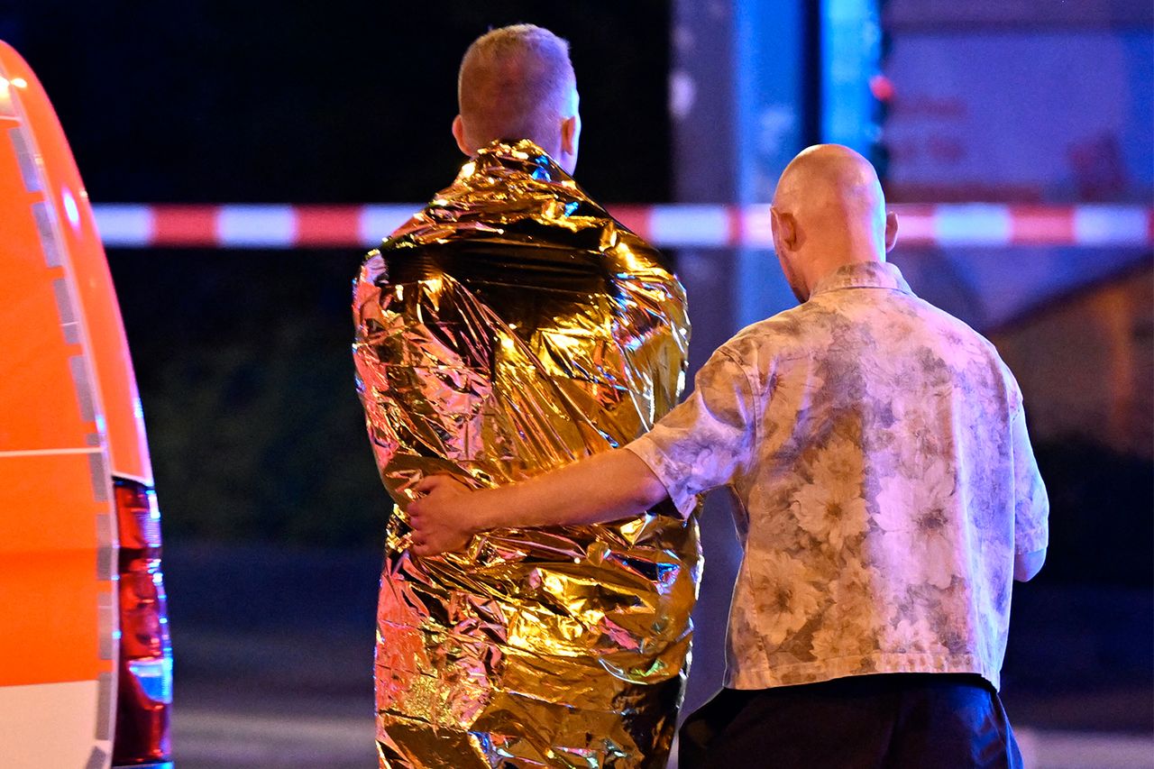 A man comforts another one who is wrapped in a security blanket near the scene where one person was killed and 16 injured after a car is believed to have hit the crowd on the outskirts of the Christopher Street Day (CSD) parade in Berlin, on July 25, 2026. A man comforts another man near the scene where a car hit the crowd on the outskirts of the Christopher Street Day parade in Berlin on July 25, 2026.Credit: RALF HIRSCHBERGER / AFP via Getty