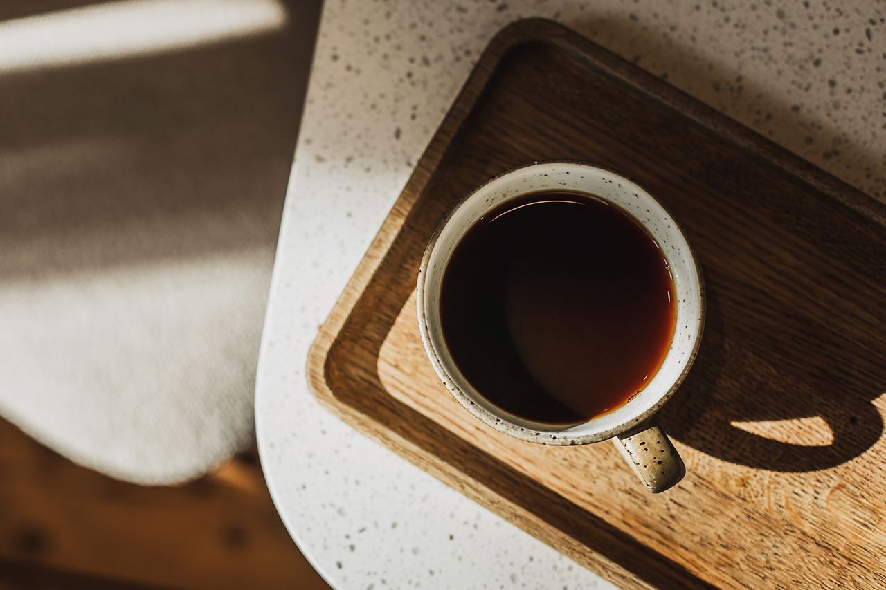 Cafe culture, long black or filter coffee. Cup with hot beverage in sunshine, majestic light and shadows on table. No people, copy space background. Cup of coffee (stock)Credit: Getty