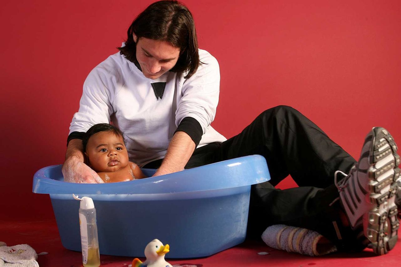 20-year-old soccer star Lionel Messi helps to bathe Lamine Yamal, who was merely six months old at the time, during a photo session in Sept. 2007 in the dressing room of the Camp Nou stadium in Barcelona, Spain.Credit: Joan Monfort/AP