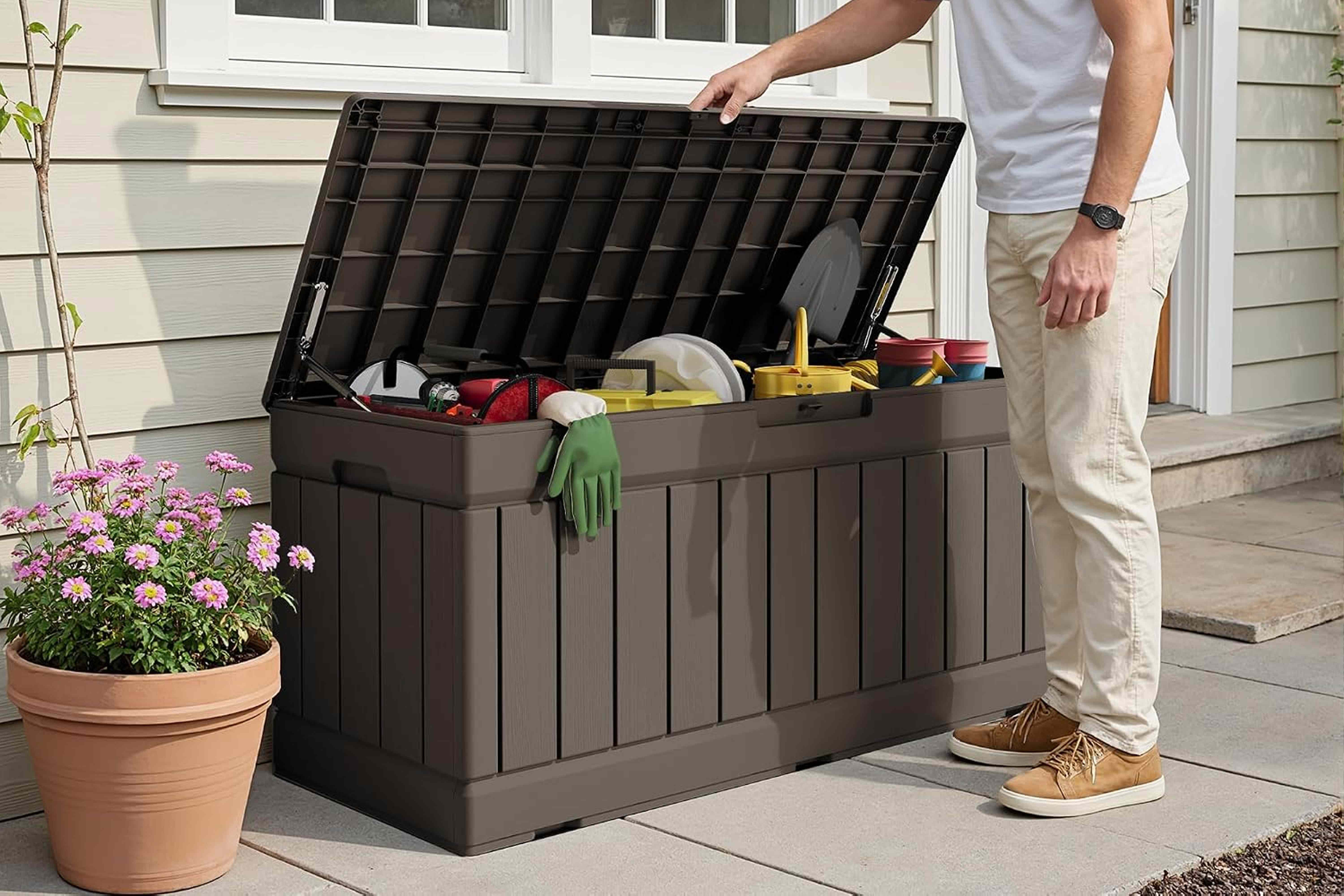 A person organizing items in an outdoor storage bin Credit: Amazon