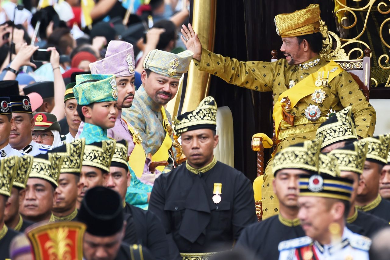 Brunei's Sultan Hassanal Bolkiah (R) waves while Crown Prince Al-Muhtadee Billah Brunei’s Sultan Hassanal Bolkiah (R) waves while Crown Prince Al-Muhtadee Billah (2nd R), Prince Abdul Malik (2nd L) and Prince Abdul Wakeel (L) look on from the royal chariot during a procession to mark his golden jubilee of accession to the throne in Bandar Seri Begawan on Oct. 5, 2017Credit: ROSLAN RAHMAN/AFP via Getty