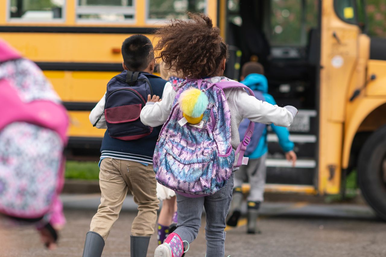 Happy children getting on school bus Happy children getting on school busCredit: Getty