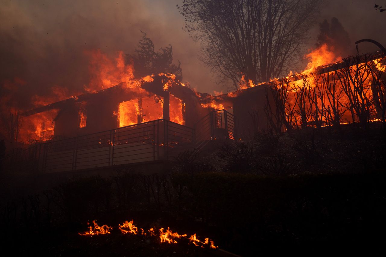 Flames from the Palisades Fire burn a home on Jan. 7, 2025 in the Pacific Palisades neighborhood of Los Angeles, CaliforniaCredit: Eric Thayer/Getty