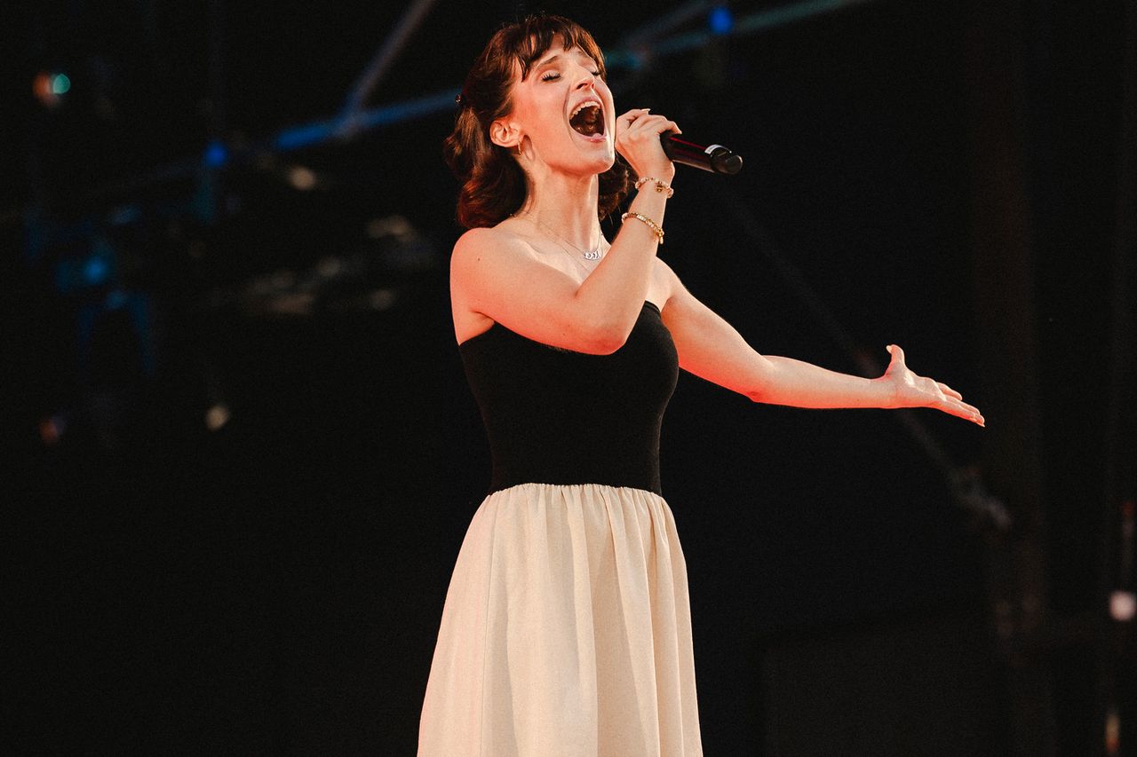 A performer singing passionately on stage with a microphone in hand at The Festival on Friday, Aug. 14 at Hutton Brickyards Riverfront Hotel + Venue in Kingston, N.Y.