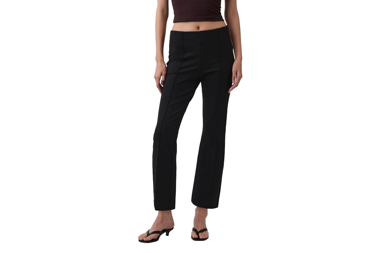 A person wearing black cropped kick pants and sandals torso visible from midsection down Credit: Gap