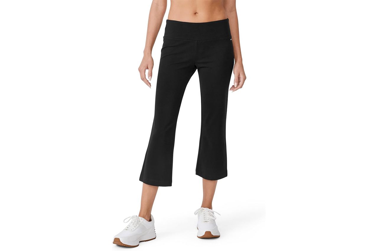A person wearing black flare capri pants and white sneakers torso and legs visible Credit: Amazon