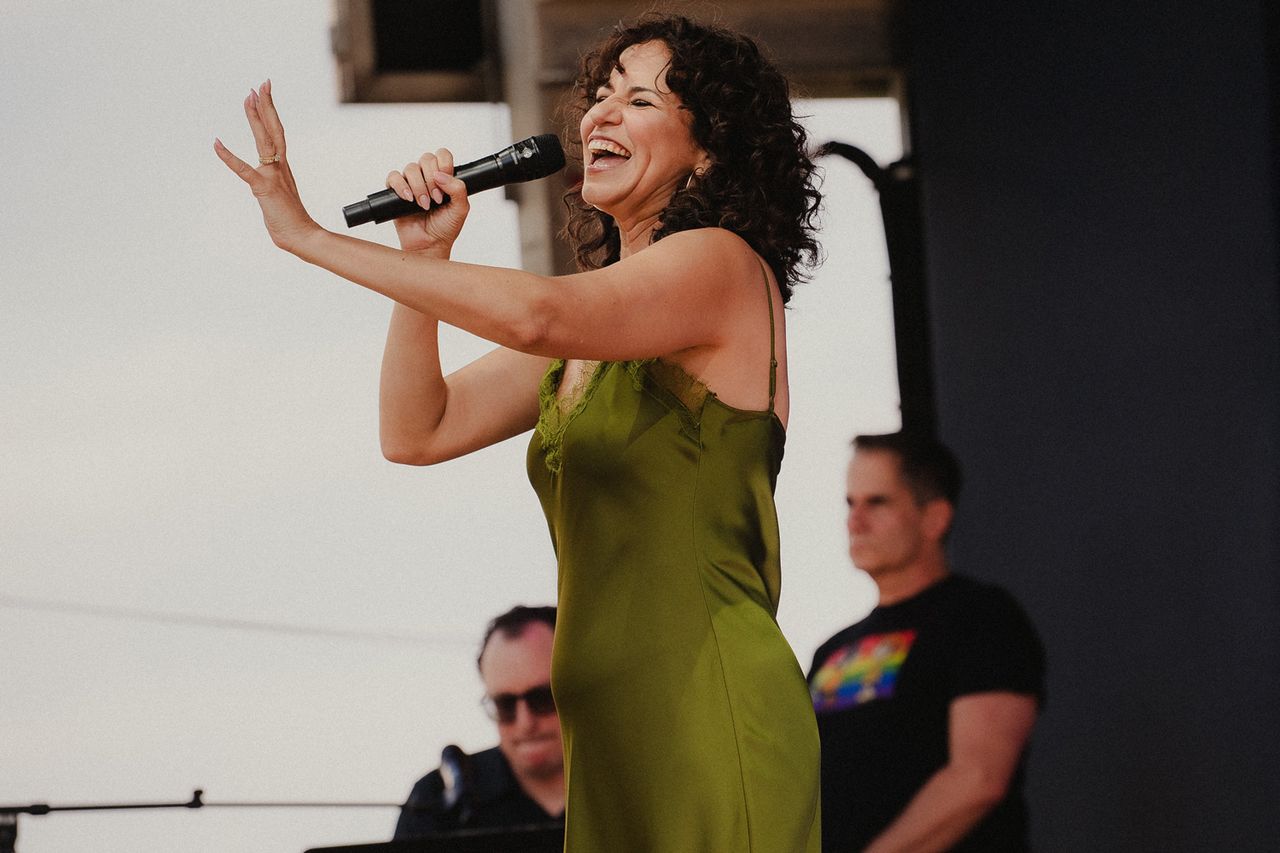 Mandy Gonzalez performing on stage with a microphone accompanied by musicians in the background Mandy Gonzalez sings at The Festival on Friday, Aug. 14 at Hutton Brickyards Riverfront Hotel + Venue in Kingston, N.Y.Credit: Michaelah Reynolds