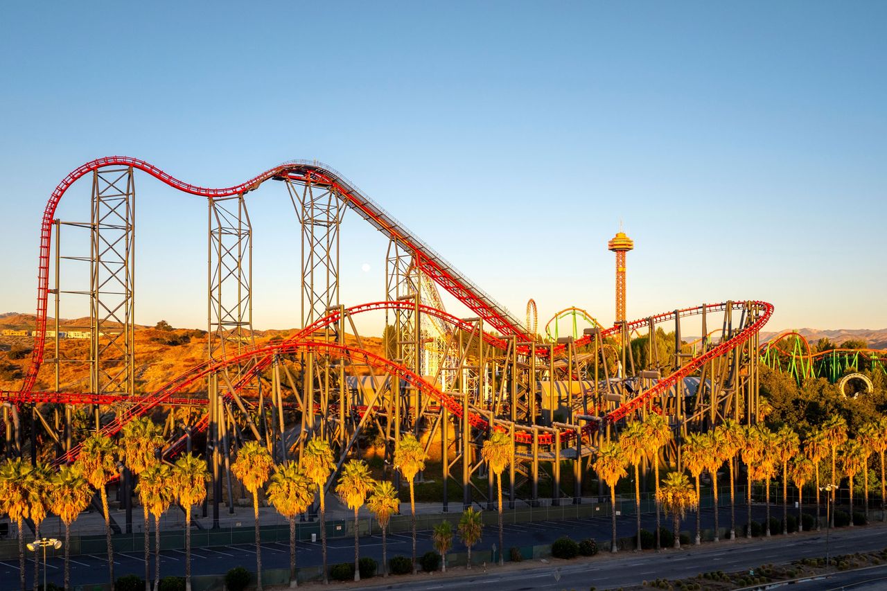 Aerial of Six Flags Magic Mountain amusement park, rollercoaster rides, trees at sunrise. X2 rollercoaster ride. X2 roller coaster ride at Six Flags Magic MountainCredit: Shutterstock
