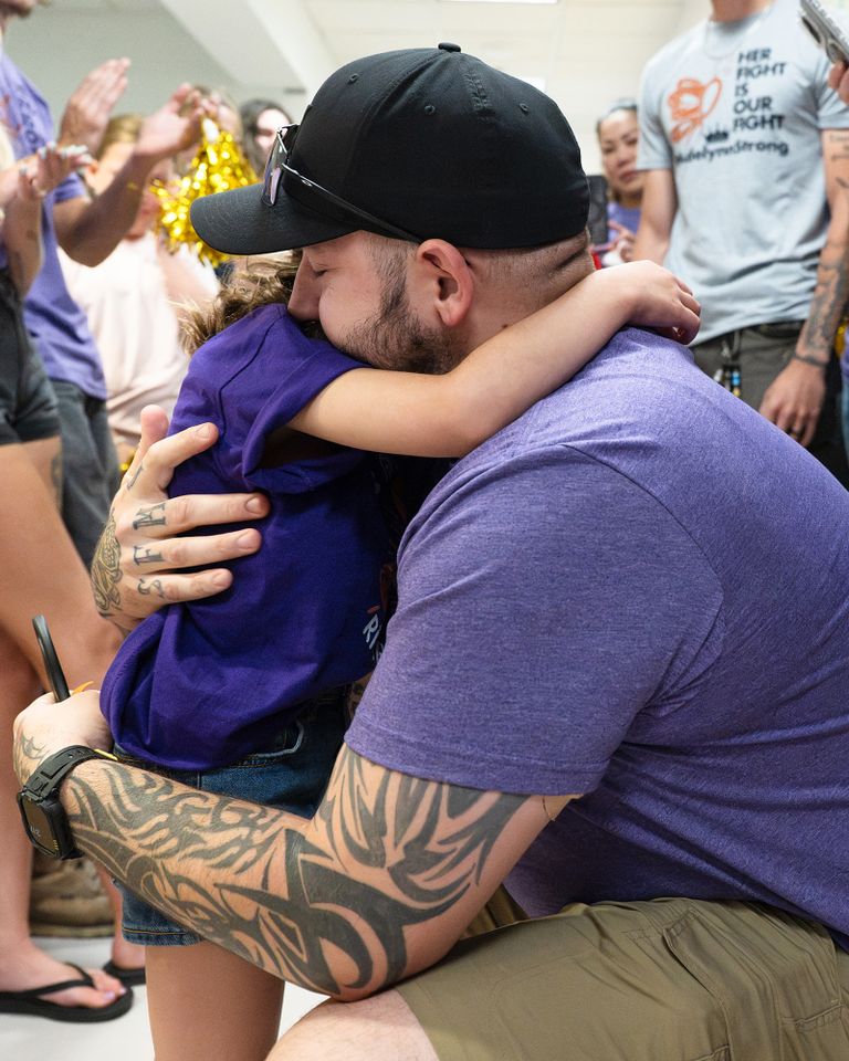 Girl, 7, Declared Cancer-Free and Cuts Off the BraceletHer Dad Wore Throughout Her Entire Treatment Adelynn Taylor hugging her dad.Credit: BDK Photography
