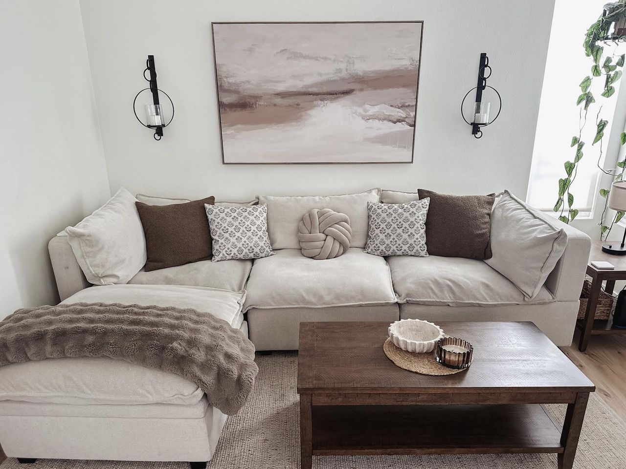 A living room showcasing a cozy sectional sofa a wooden coffee table and wallmounted decor Credit: People / Jeaneen Russell