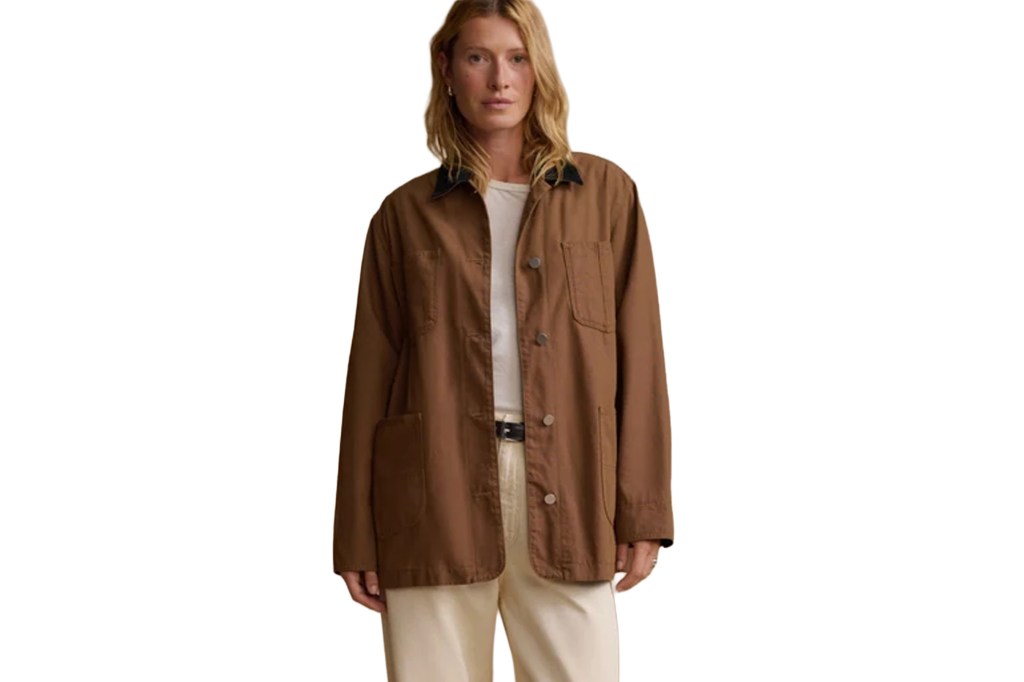 A woman wearing a brown coat and light-colored pants.
