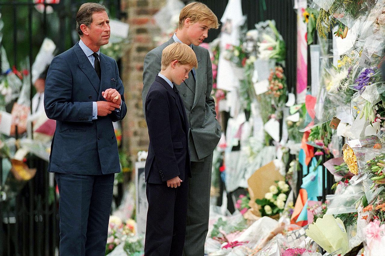 The Prince of Wales, Prince William and Prince Harry look at floral tributes to Diana, Princess of Wales outside Kensington Palace on September 5, 1997 in London, England. From left: Prince Charles, Prince Harry and Prince William looking at tributes to Princess Diana on Sept. 5, 1997.Credit: Anwar Hussein/WireImage